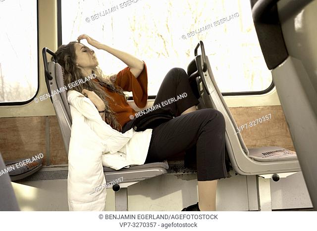 young woman sitting in public transport, in city Cottbus, Brandenburg, Germany