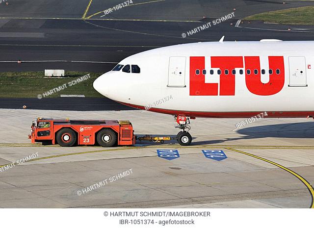 LTU commercial aircraft in the manoeuvring area with marshalling yard vehicle, Duesseldorf International Airport, North Rhine-Westphalia, Germany, Europe