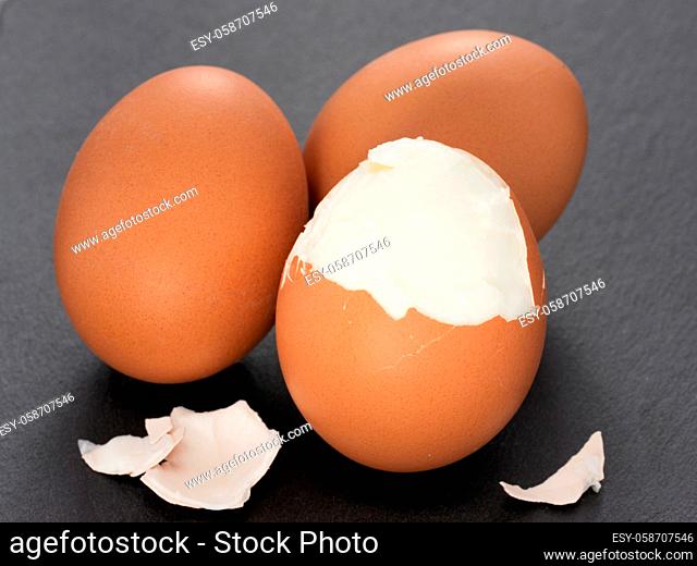 three boiled eggs with egg shell on slate gray background. Close up