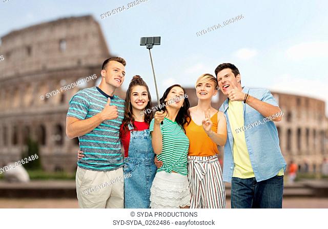 friends taking selfie by monopod over coliseum