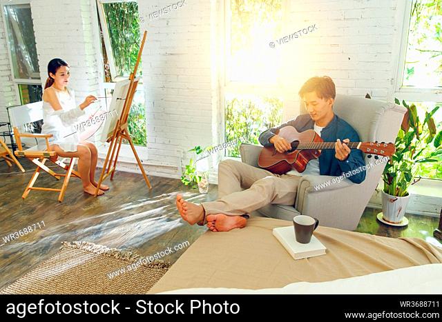 Happy young couples guitar drawing at home