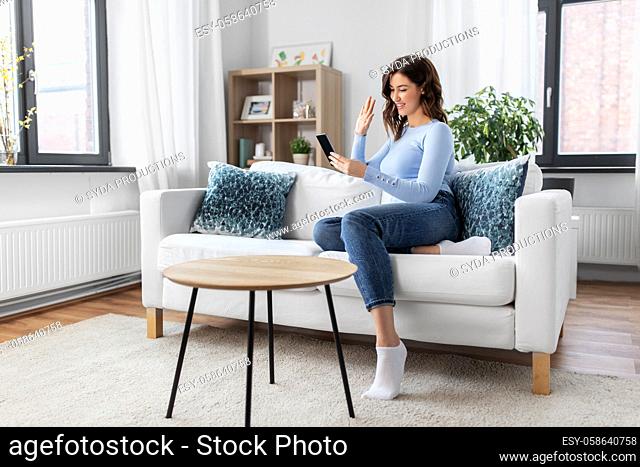 woman with smartphone having video call at home