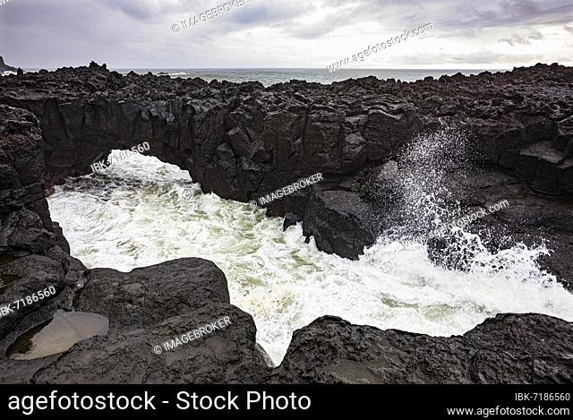 Lava arch on the volcanic coast at high tide with high waves, Ponta da Ferraria, Sao Miguel Island, Azores, Portugal, Europe