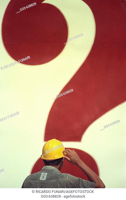 Construction worker in front of a question mark