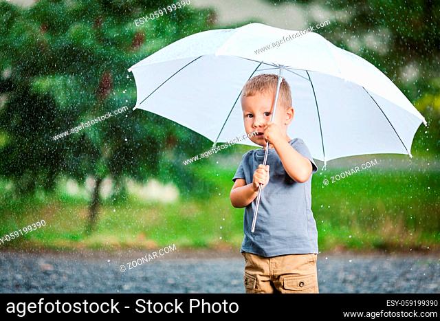 Adorable child holding an umbrella during a rain storm