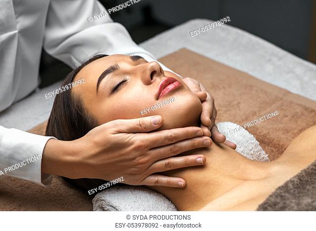 woman having face and head massage at spa