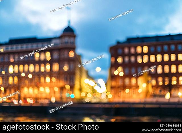 Helsinki, Finland. Abstract Blurred Bokeh Boke Background Of Crossroad Of Pohjoisranta And Kirkkokatu Street In Evening Or Night Illumination