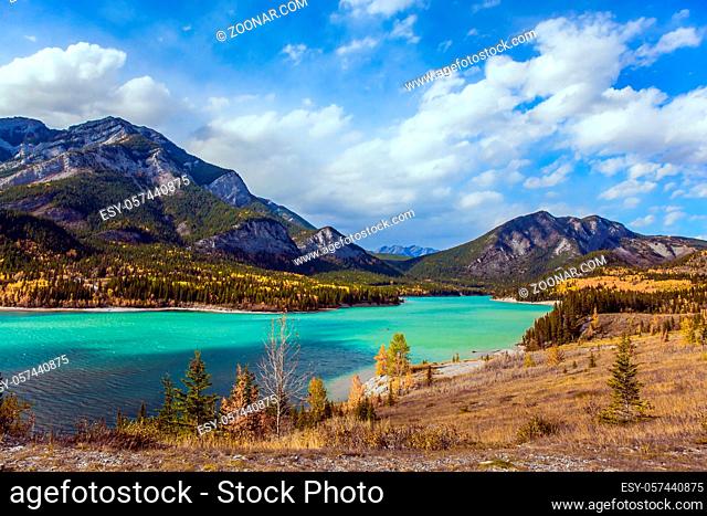 Lush multicolor autumn in the Canadian Rockies. The valley and azure icy water of the Kananaskis river. The concept of active, ecological and photo tourism