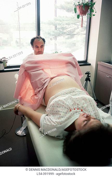 Doctor performs pelvic exam on pregnant female