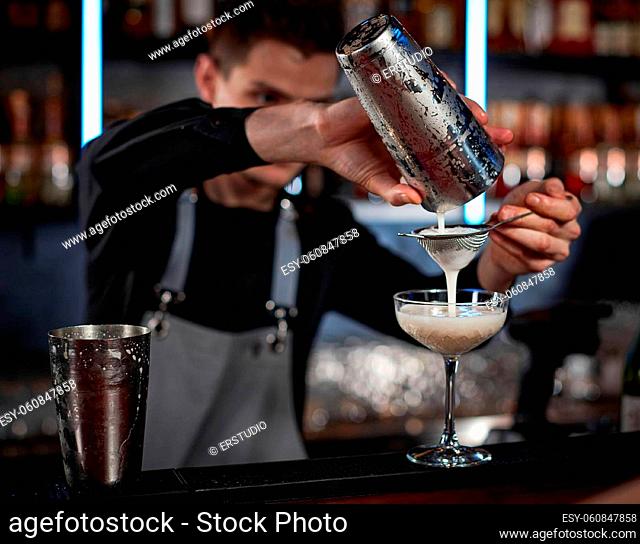 professional bartender makes cocktail in nightclub