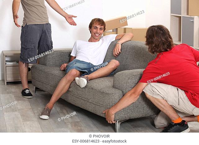 Three young men moving room