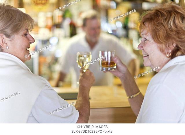 Older women toasting each other at bar