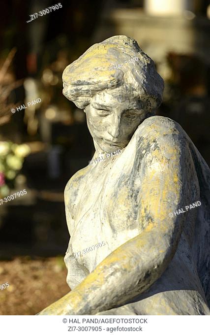 bronze sculpture of woman at historical monumental Staglieno Cemetery in town, shot in bright winter light in Genova, Liguria, Italy