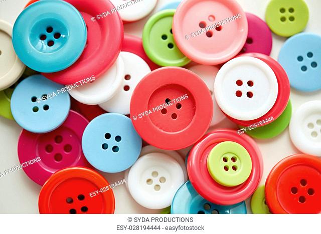 needlework and tailoring concept - sewing buttons