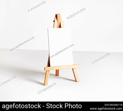 Blank business card on wood holder at white paper background. Responsive design template