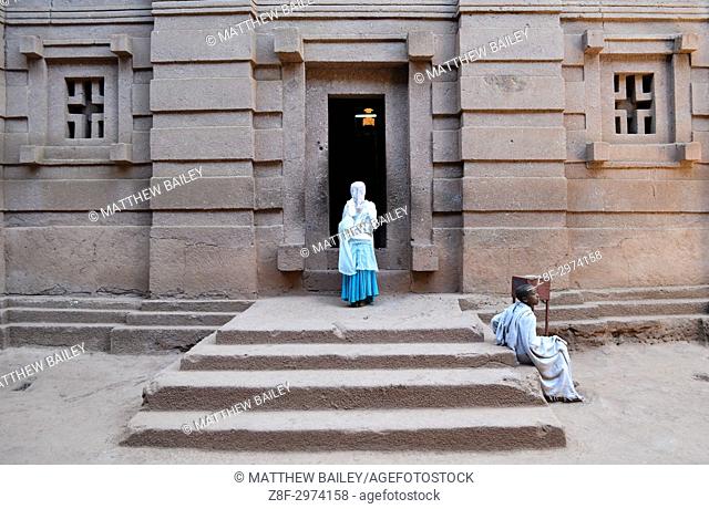 A woman prays in the doorway of Biete Amanuel underground monolithic church in Lalibela, Ethiopia