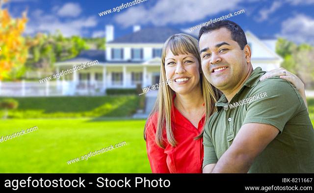 Happy mixed-race couple in front of beautiful house