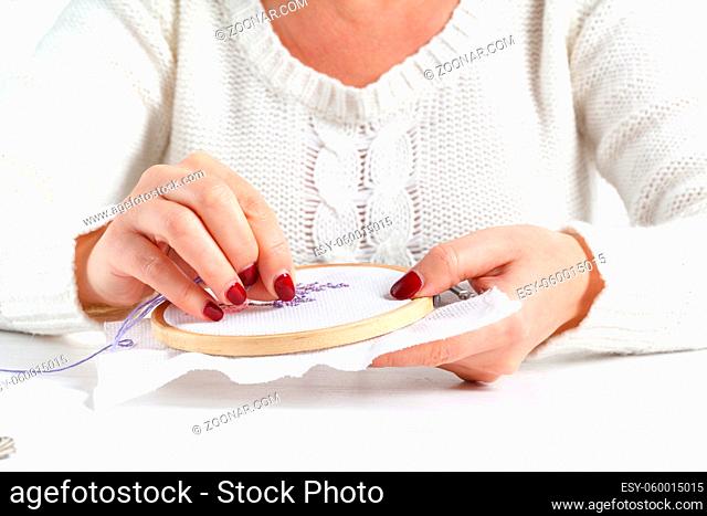 woman embroidering cross lavender
