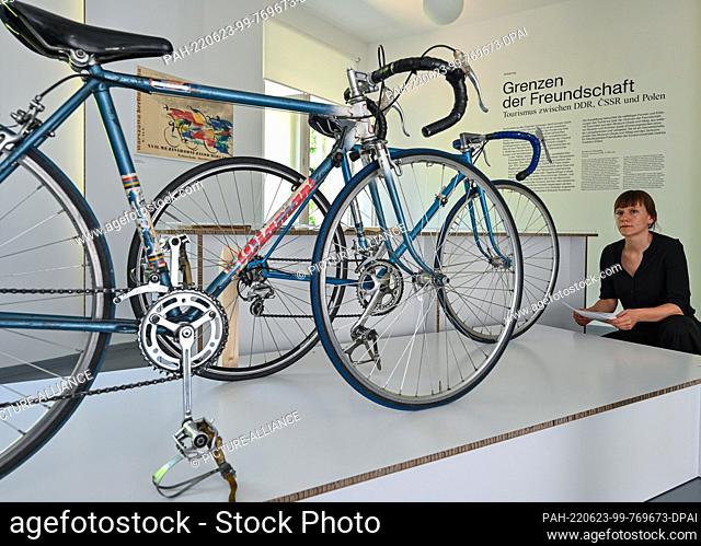 23 June 2022, Brandenburg, Eisenhüttenstadt: Florentine Nadolni, director of the Museum Utopia and Everyday Life, looks at racing bikes from the 1970s and 1980s...