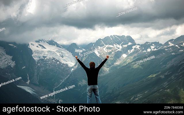 happy traveller on the top of mountain stormy landscape