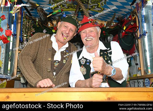 17 September 2022, Bavaria, Munich: Bird whistlers Tobi and Horst Berger laugh in their booth at the start of the 187th Munich Oktoberfest
