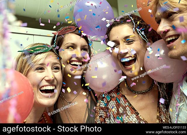 Cheerful friends smiling while enjoying party together