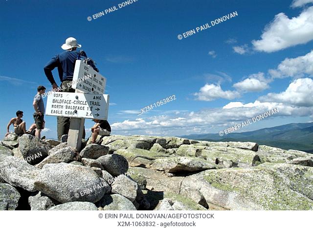 Hikers relax on the summit of South Baldface Mountain in the scenic landscape of the White Mountains, New Hampshire USA during the spring months  Notes:\