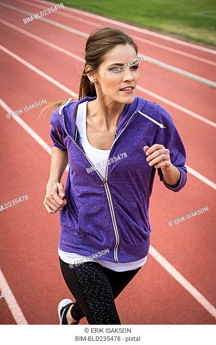 Caucasian woman running on track