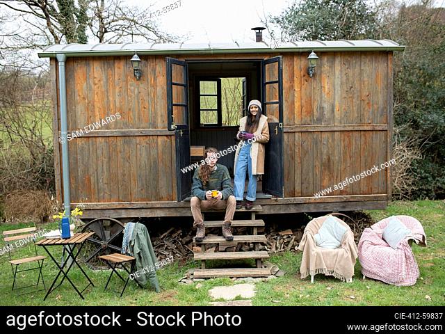 Portrait young couple in tiny cabin rental doorway