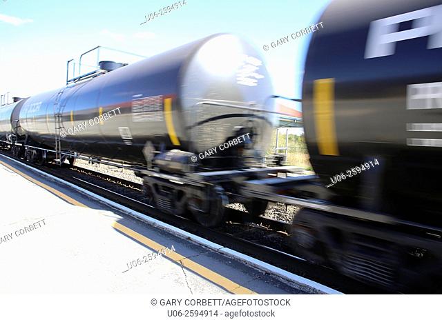 A train carrying dangerous chemicals in tank cars along a railroad