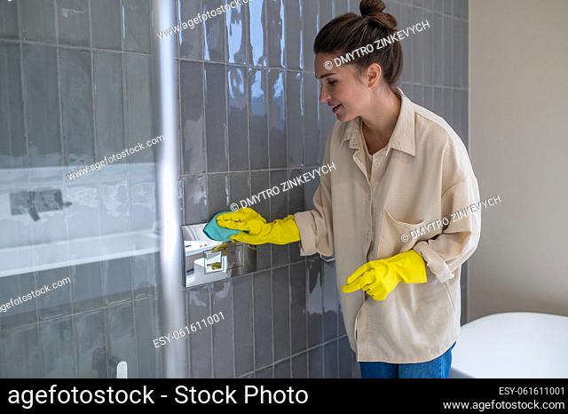 House work. Young housewife looking busy while cleaning in the bathroom