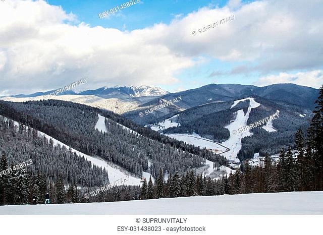 Skiers and snowboarders enjoying on slopes of ski resort Bukovel, Ukraine