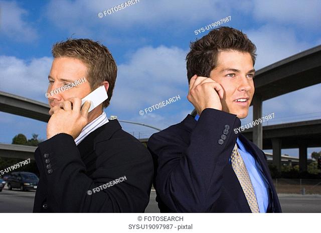 A Pair of Businessmen Talking on a Cellular Phone, Waist Up