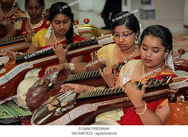 Tamil Hindu girls perform a devotional song on the veena during the Mancham Narayanan Perumaal Festival (which honours Lord Vishnu) at a Tamil Hindu temple in...