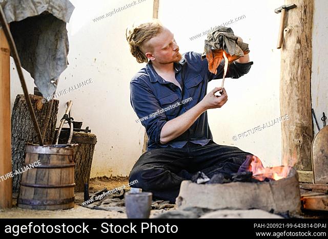 15 September 2020, Hessen, Lorsch: Metal designer Pierre Stoll is working in the Lauresham open-air laboratory on a fireplace at the end of the strap for a...