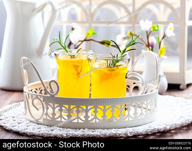 Fresh lemon drink with rosemary in glass cup