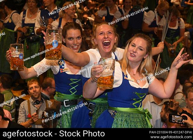 03 October 2023, Bavaria, Munich: Waiters and waitresses celebrate the end of the Wiesn with guests at the traditional Kehraus in the Hofbräuzelt