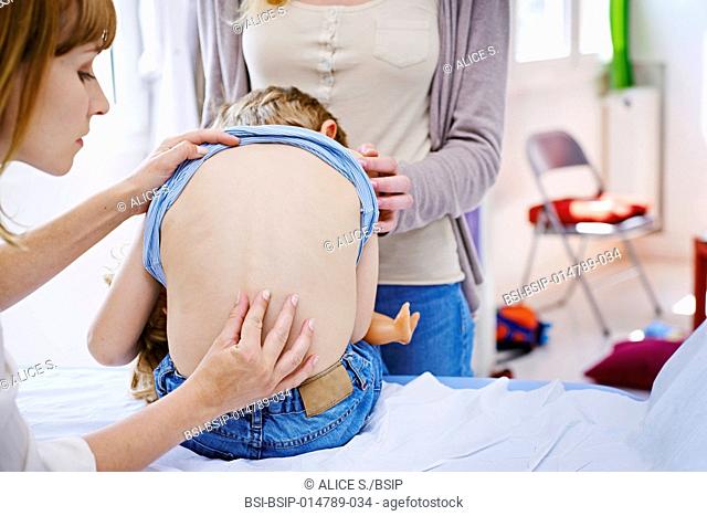 Doctor examining a child's back
