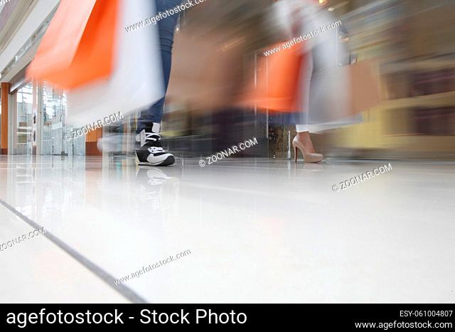 Women walking fast in shopping mall with bags sale rush concept