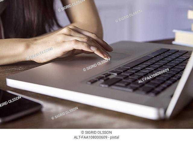 Woman's hand on laptop computer touch pad