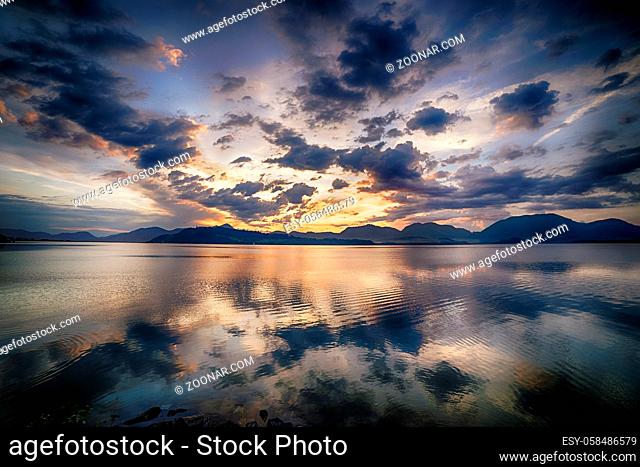 Sunset landscape, lake with beautiful clouds in the background