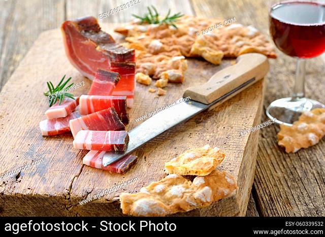 Südtiroler Jause: Deftiger Speck mit knusprigem Schüttelbrot, dazu regionaler Rotwein ? Typical South Tyrolean snack with country bacon and local crunchy flat...
