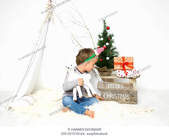 christmas scene with blond young and small christmas tree