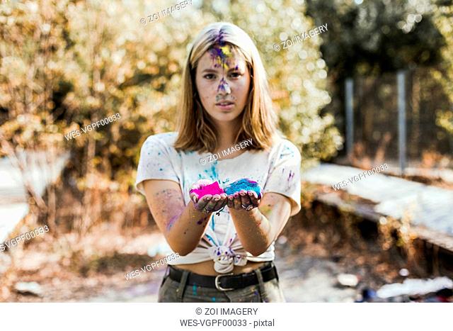 Girl holding Holi powder colours, Germany