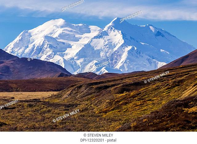 Denali rises in the distance, viewed from inside Denali National Park in autumn; Alaska, United States of America