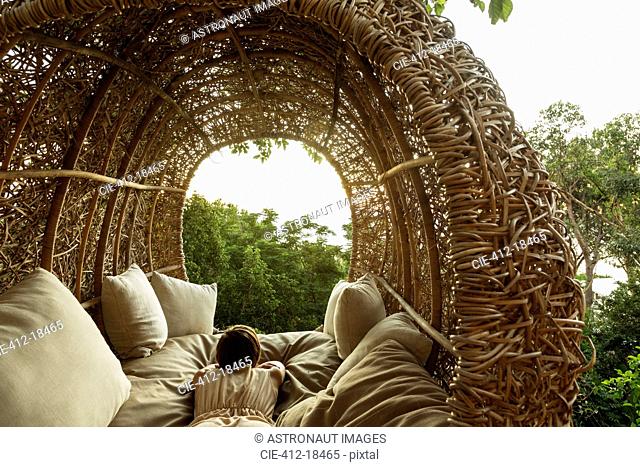 Woman laying in nest tree house