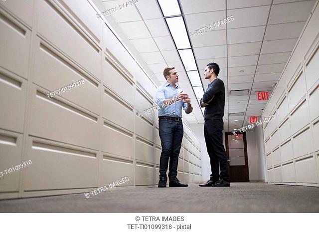 Young men talking to each other in corridor