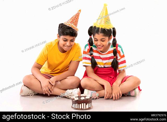 Excited boy and girl celebrating birthday together