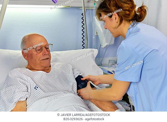 Nurse taking a patient's blood pressure, hospital room, Hospital Donostia, San Sebastian, Gipuzkoa, Basque Country, Spain