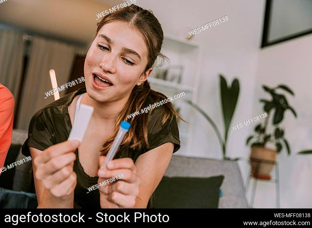 Girl looking at COVID-19 test kit at home